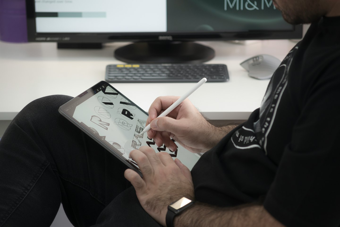 Designerin benutzt einen Stift auf einem Tablet und erstellt digitale Typografie.